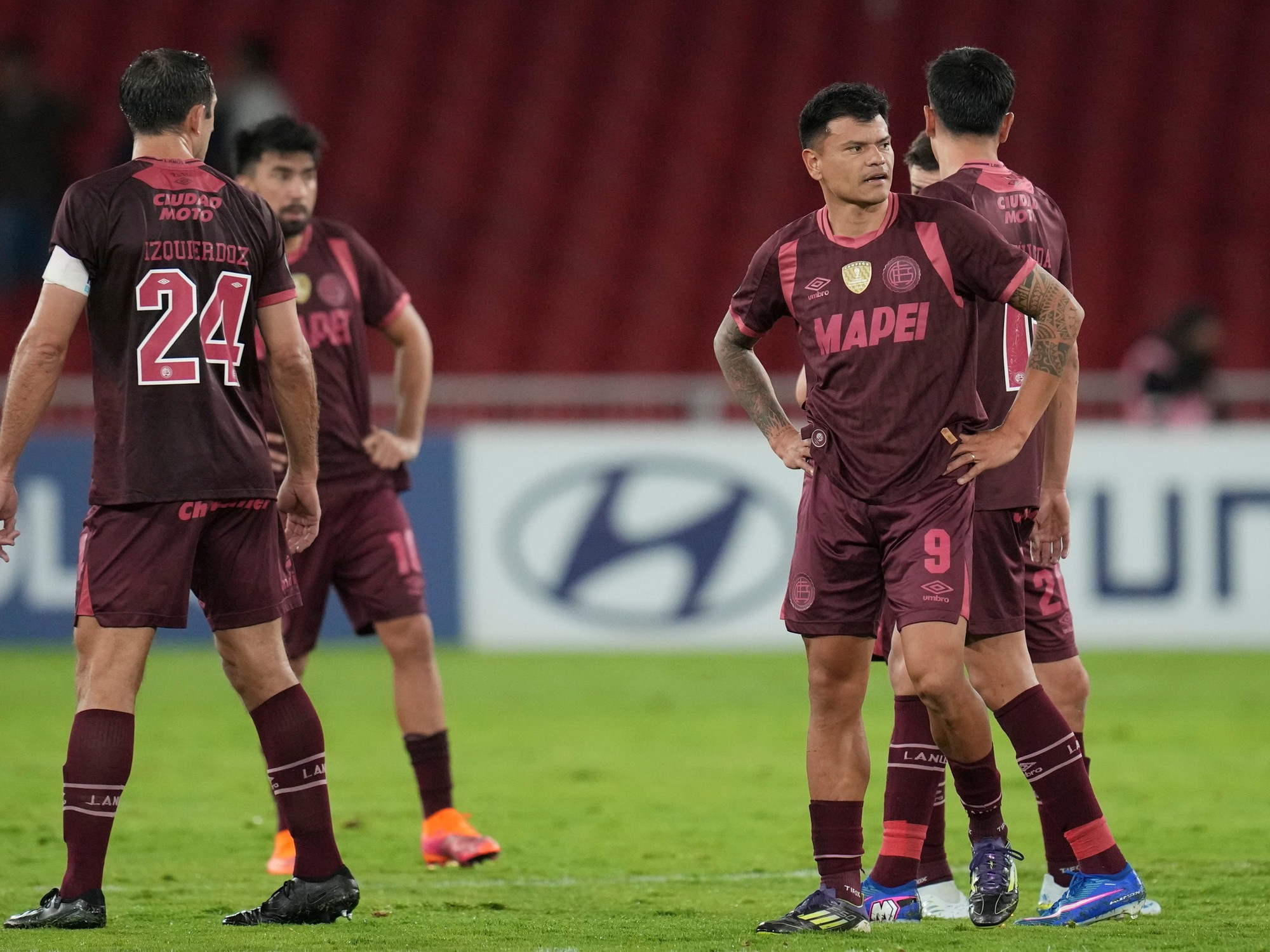 Jugadores de Lanús lamentan un gol en contra durante el partido contra Liga de Quito por la Copa Libertadores.