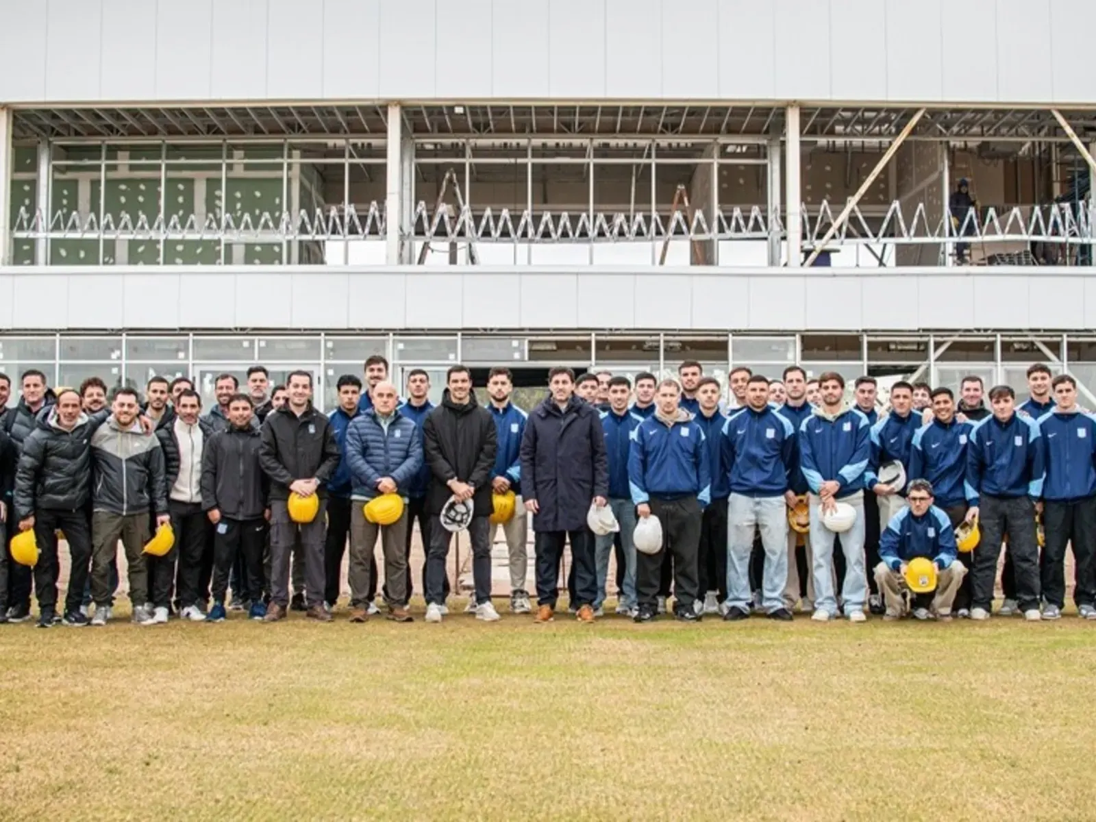 Jugadores de Racing observan las obras en el predio de Ezeiza junto a directivos.
