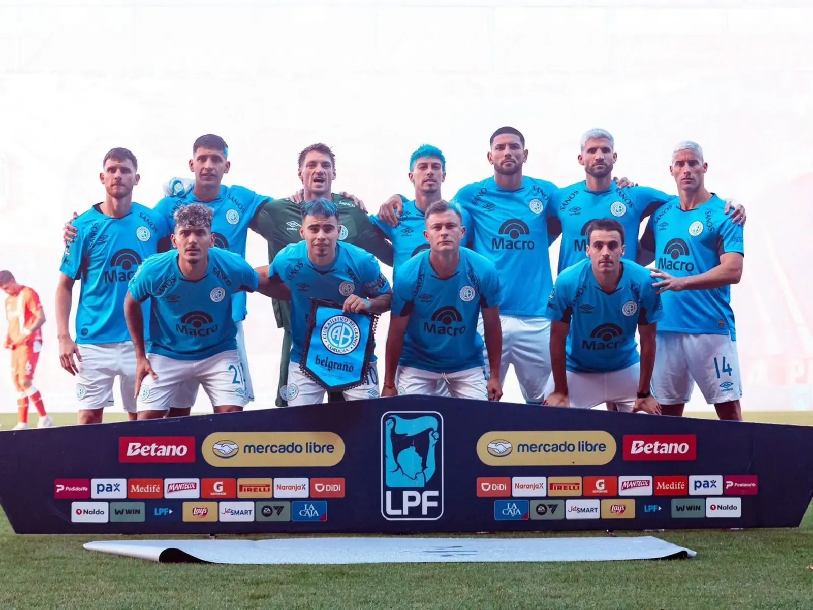 Jugadores de Belgrano celebran un tanto en el campo de juego.