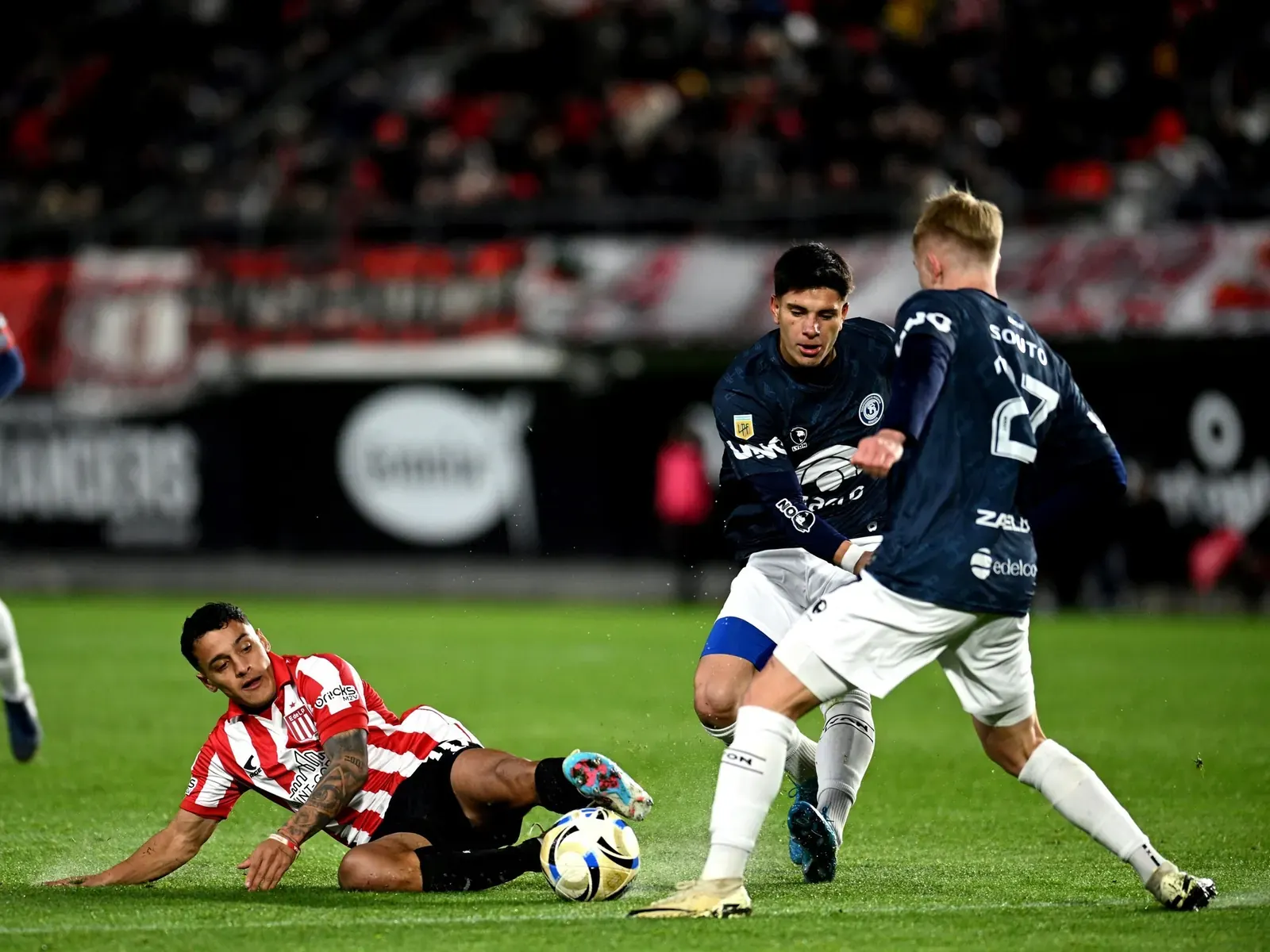 Jugadores de Estudiantes de La Plata y un jugador de Independiente Rivadavia disputando un balón en un partido de fútbol.