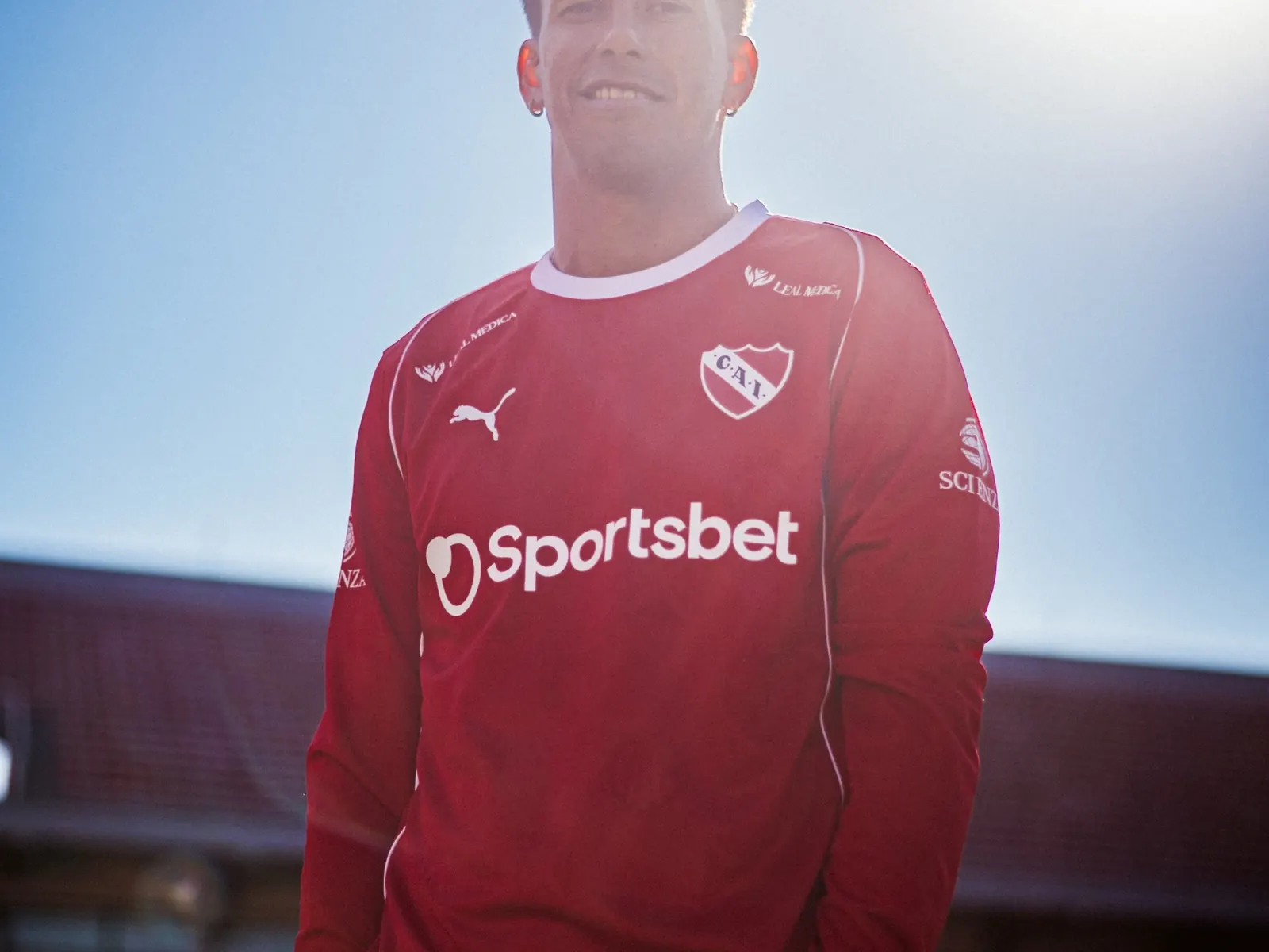 Maximiliano Meza sonriendo mientras posa con la camiseta de Independiente.