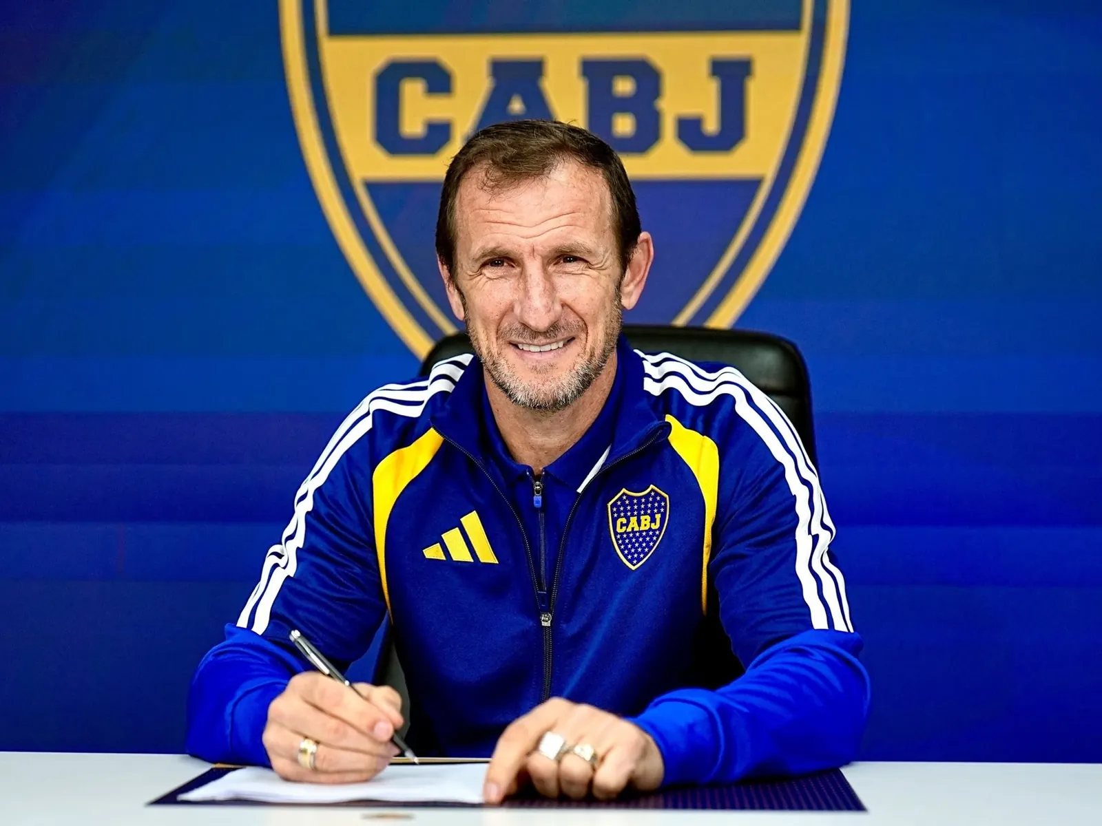 Rodolfo Arruabarrena, nuevo director técnico de Boca Juniors, sonríe mientras firma su contrato.