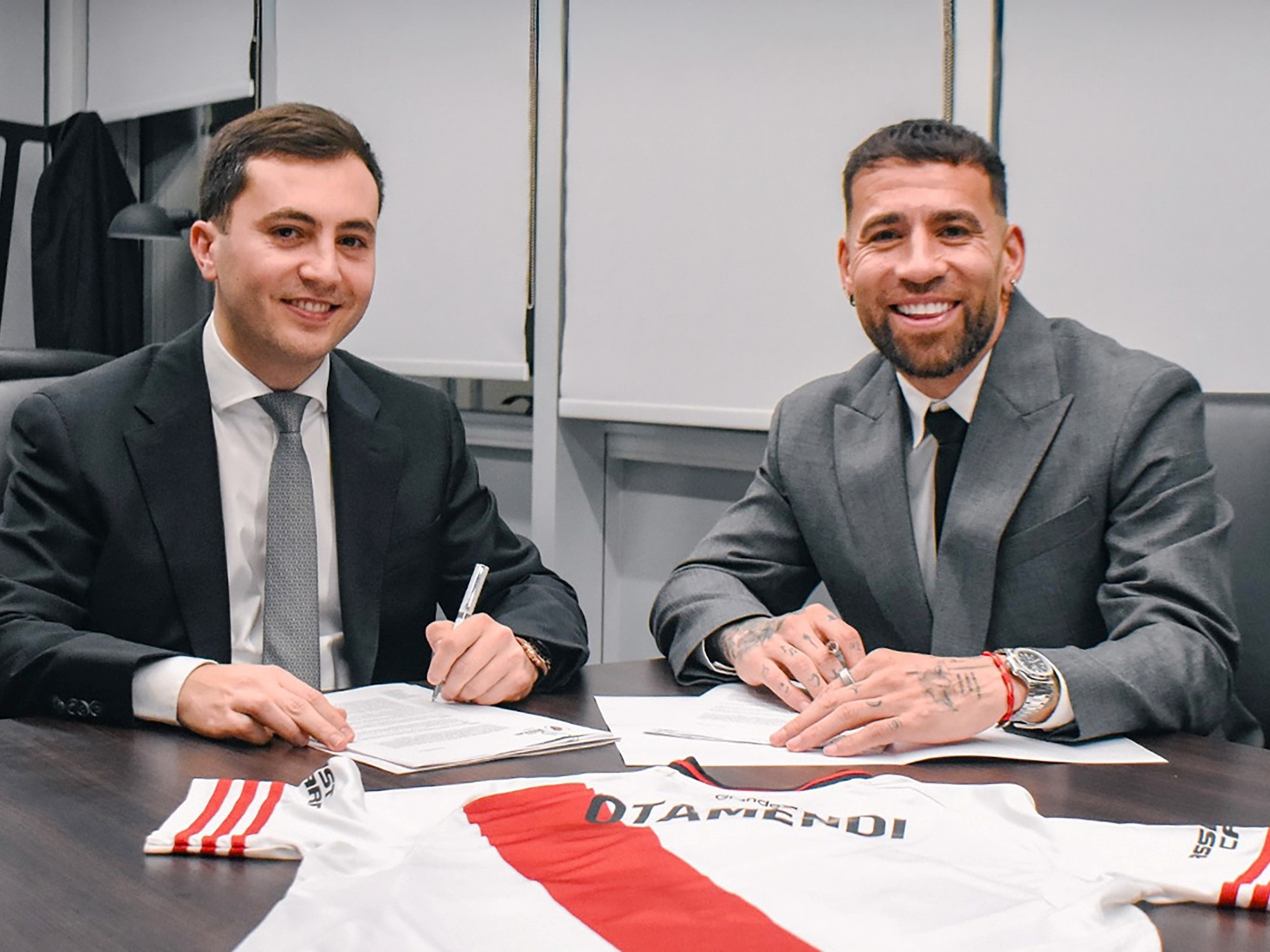 Nicolás Otamendi sonríe mientras firma su contrato con River Plate en las oficinas del club.