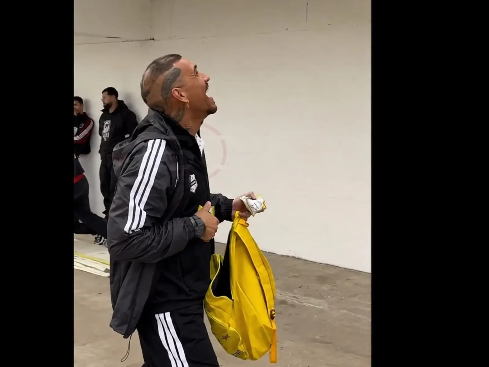 Ignacio Arce, arquero de Deportivo Riestra, entregando paquetes de alfajores a niños sentados en la tribuna antes del partido contra Defensa y Justicia