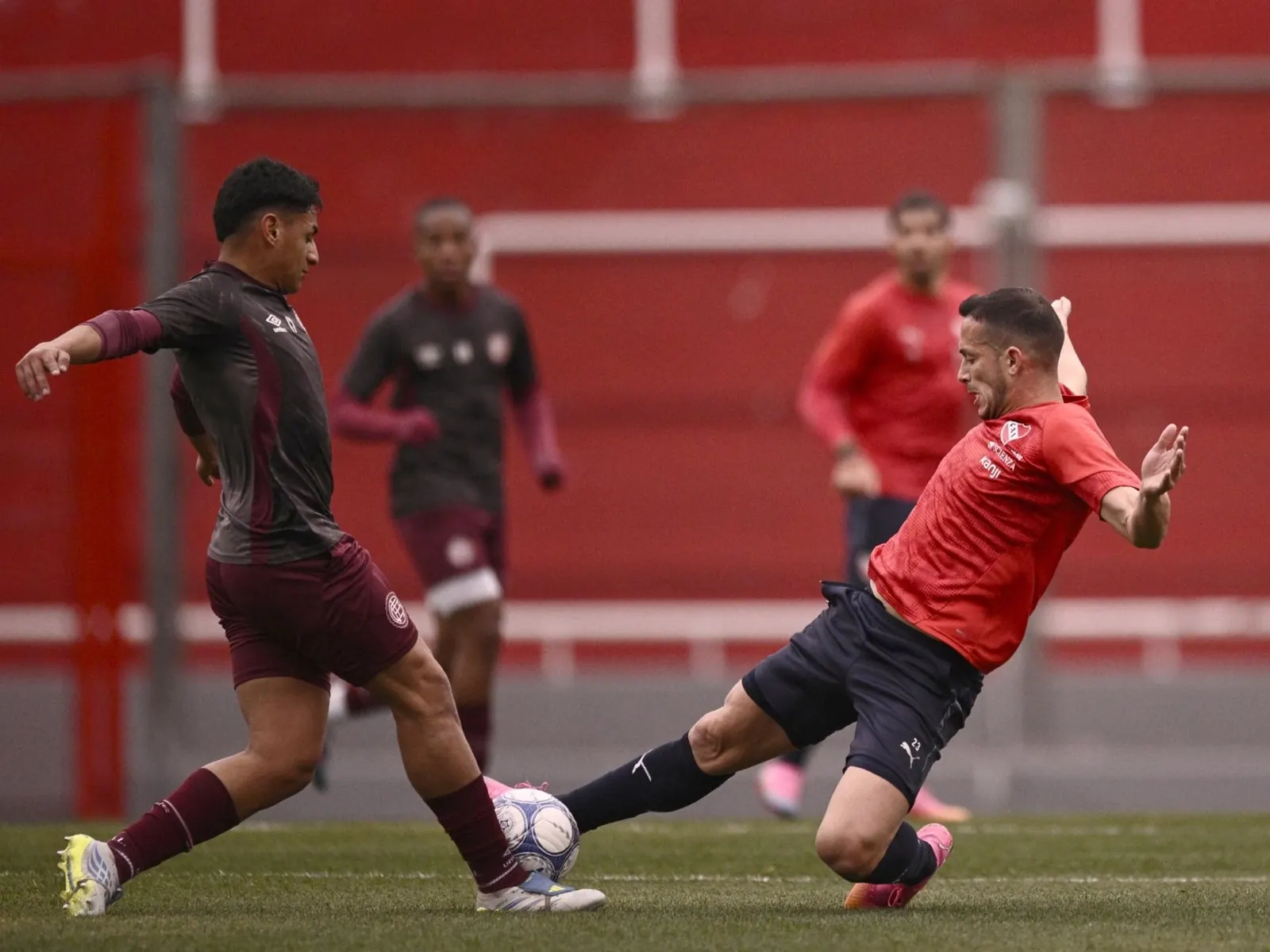 Jugadores de Independiente y Lanús disputando un balón durante un partido amistoso de pretemporada.