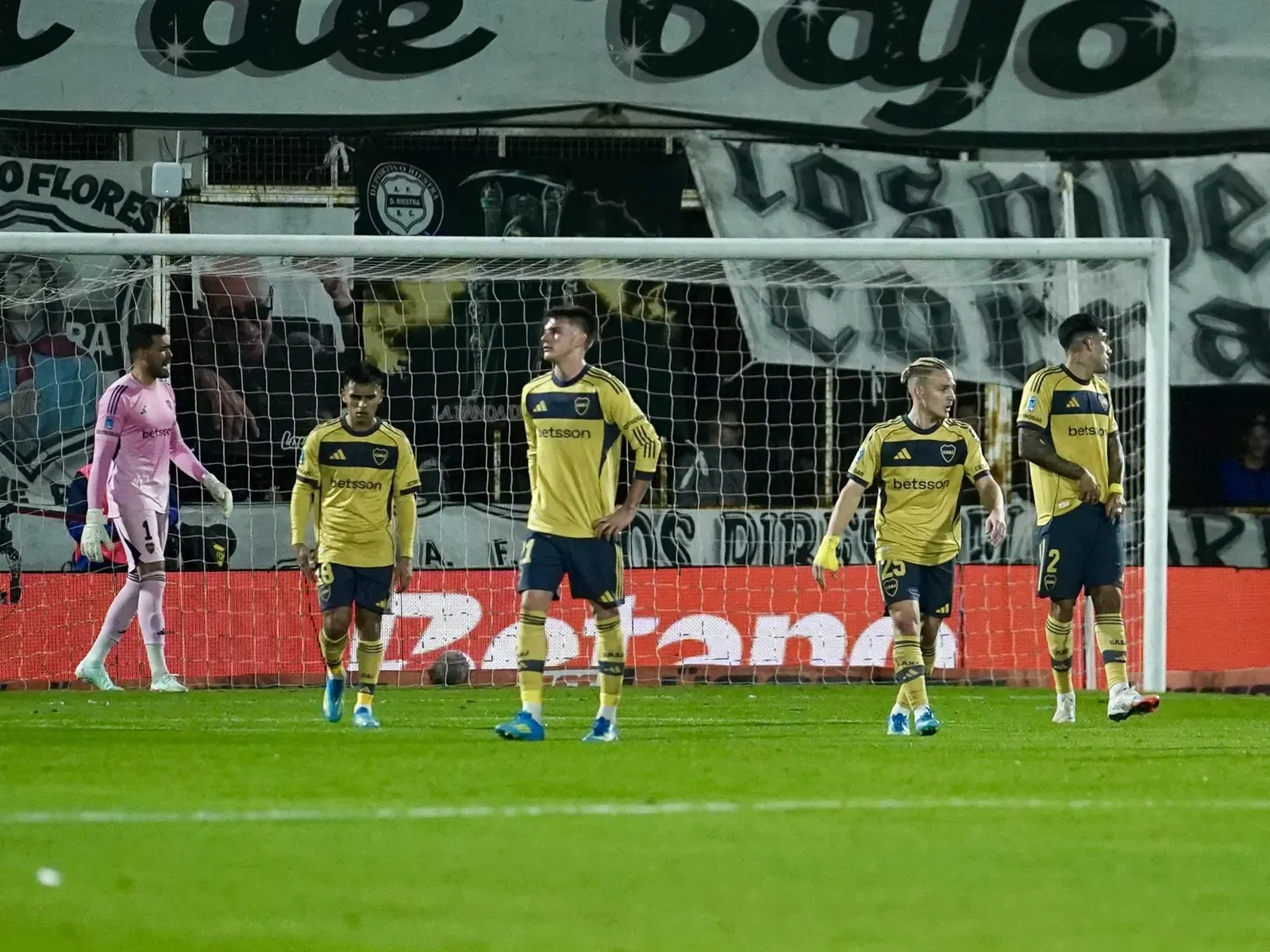 Boca Juniors defenders Di Lollo and Pellegrino watch helplessly as Riestra's Braian Sánchez heads the ball to score the first goal in the 2026 Clausura match