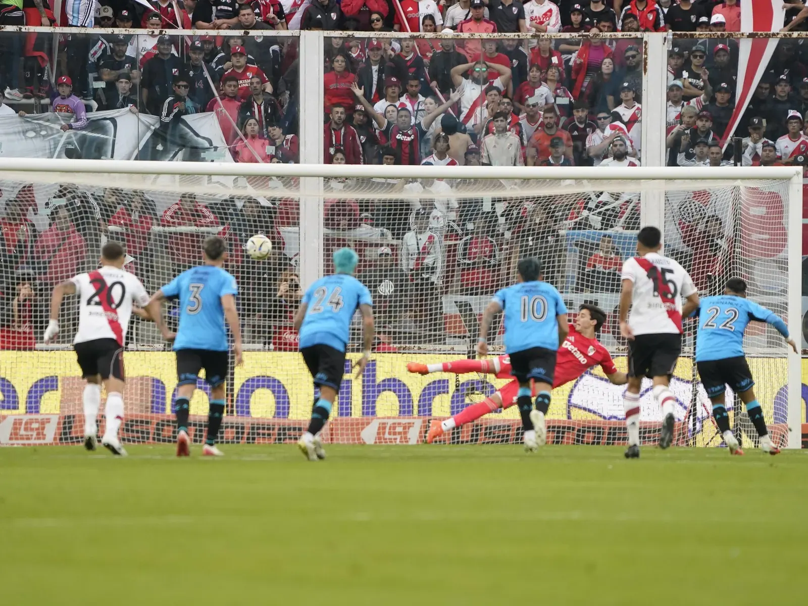 Jugadores de Belgrano celebran la victoria contra River Plate en la final del Torneo Apertura, con el trofeo en alto.