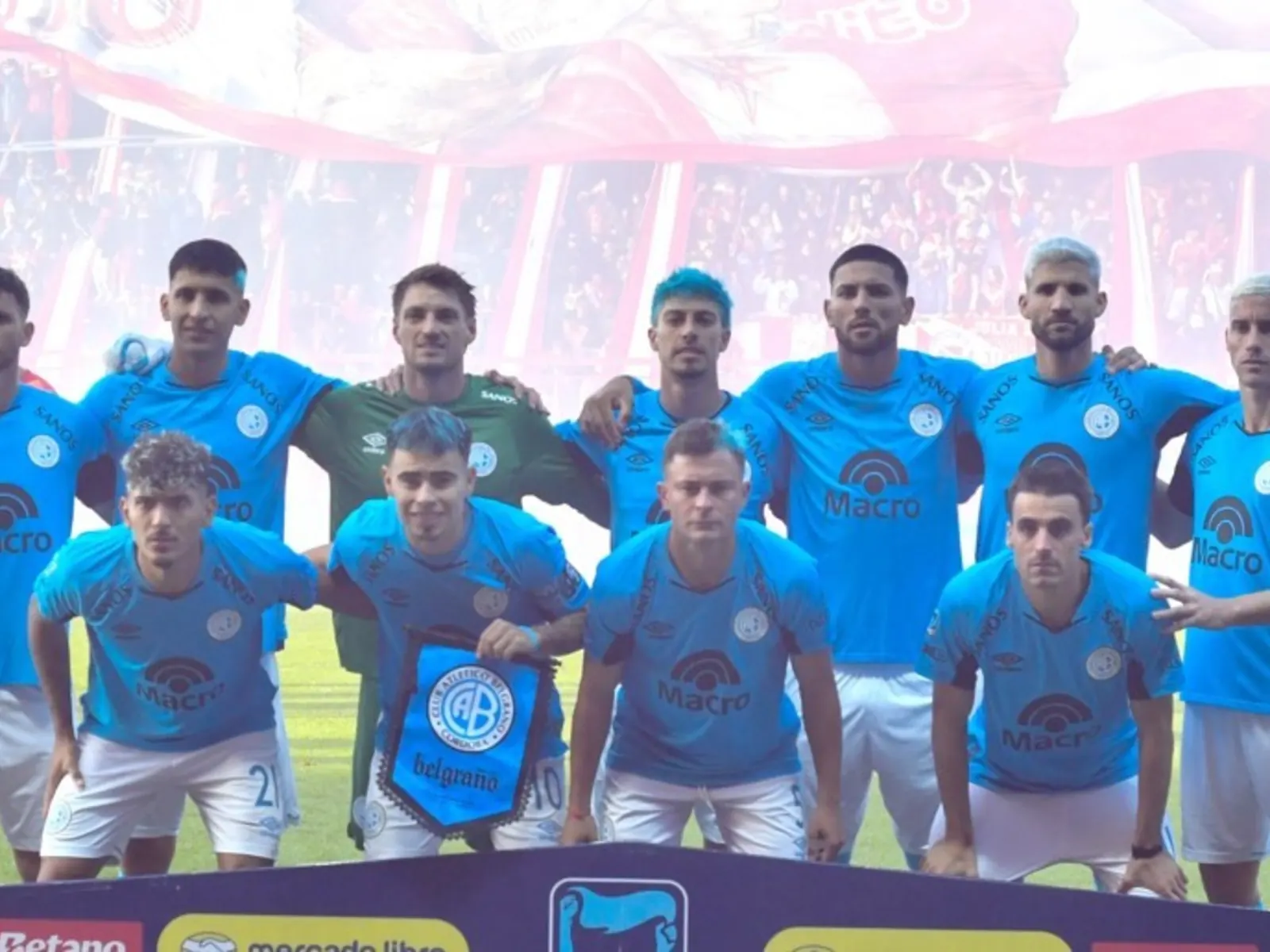Jugadores de Belgrano celebrando un gol en un partido de fútbol.