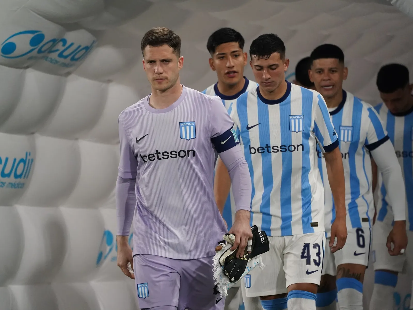 Racing Club players celebrate after scoring against Sarmiento in the Torneo Clausura, with Gonzalo Escudero and Maravilla Martínez highlighted